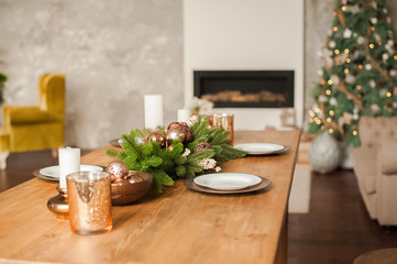 Christmas living room decor and copy space. Rustic living room with a table set for Christmas. Details of a Scandinavian living room with a festive table.