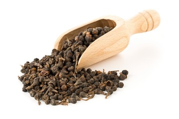 Heap of raw, dried cinnamon blossom buds spice in wooden scoop over white