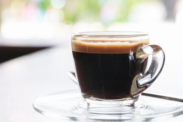 Glass of espresso on wooden table with copy space.