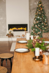 Christmas living room decor and copy space. Rustic living room with a table set for Christmas. Details of a Scandinavian living room with a festive table.
