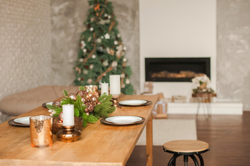 Christmas living room decor and copy space. Rustic living room with a table set for Christmas. Details of a Scandinavian living room with a festive table.