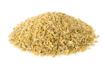 Heap of uncooked, raw freekeh or firik, roasted wheat grain over white