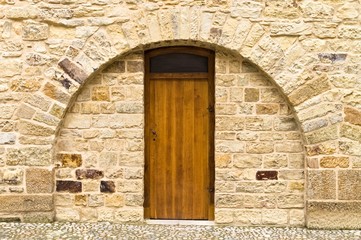 Isolated wooden door in a brick wall with a rounded arch (Prague, Czech Republic, Europe)