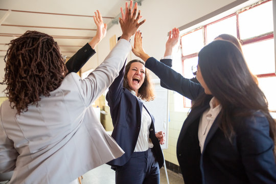 Successful Creative Business Team Giving High Five. Group Of Young Women Standing In Circle And Rejoicing. Teamwork Concept