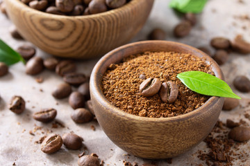 Coffee background. Coffee beans and ground powder on a stone concrete tabletop.