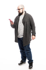 Fototapeta premium Bald man in glasses with a phone in his hands. Full height. Isolated over white background. Vertical.