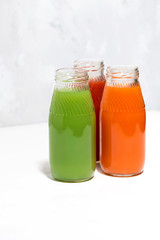 colorful vegetable juices in bottles on white background