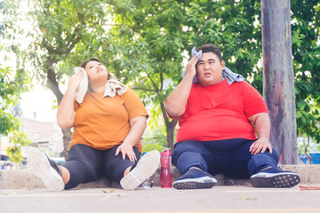 Fat Asian couple wiping their sweats after workout