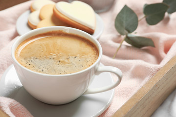 Aromatic coffee on wooden tray, closeup. Tasty breakfast