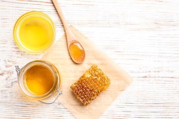Tasty aromatic honey on white wooden table, flat lay. Space for text
