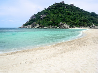 Fototapeta na wymiar Idyllic tropical paradise beach white sand and crystal clear sea blue sky with green hill Island.