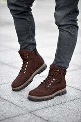 man standing on suede shoes put on leg on the pavement