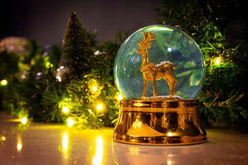 Snow globe with deer on a marble table decorated for Christmas