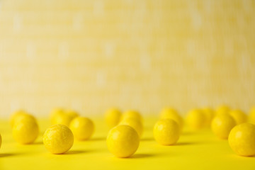 Delicious lemon chewing gums on yellow table