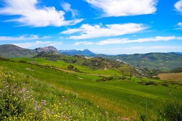 Fototapeta na wymiar A romantic view of the beautiful mountains and the colorful landscape with hills of meadows and rocks. Blue sky bushy white clouds. Spain nature