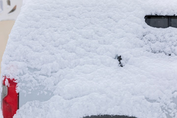Part of a car covered with snow