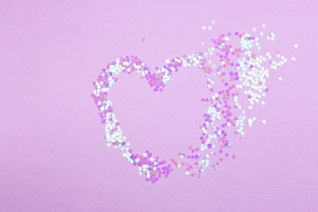 Broken heart made from confetti on pink background. Broken heart breakup concept separation and divorce image.