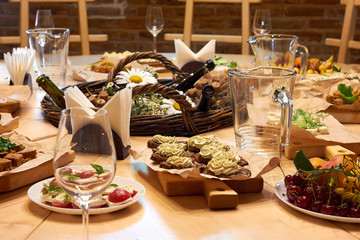 Served wooden table with a set of variety snacks, different vegetable salads, salad, pickle carrot, kavarma, rye bread sandwiches with soft cheese cream, fruits,