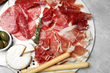 Tasty prosciutto served on light grey marble table, flat lay