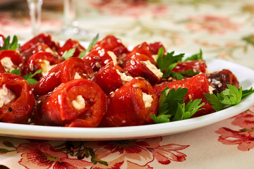 Rolls from bell red pepper with soft cheese on the plate	