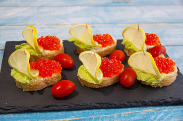 Red caviar sandwich with lemons and tomatoes