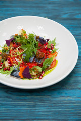 Escabeche fish dish with caviar: mackerel in marinade with vegetable, on a plate on the wooden blue background.