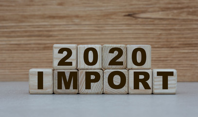 concept word import with the number 2020 on cubes on a wooden background