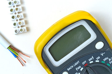 wire cutters, stripped wire, tester and terminal block. on a white background, top view.