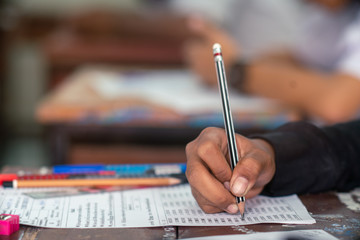 Hand of Student doing test or exam  in classroom of school with stress