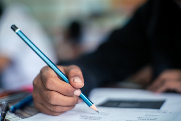 Hand of Student doing test or exam  in classroom of school with stress