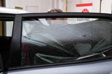 Installation of window film on car Windows. Protection from UV light.