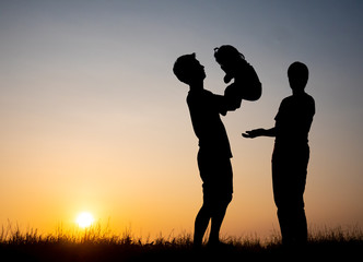 Silhouette family,father, mother and children against the sunset.