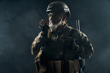 Old military commander holding radio station.