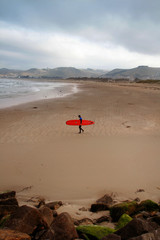 Fototapeta na wymiar Surfista con tabla roja en California