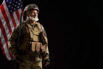 Old military officer holding sniper rifle.