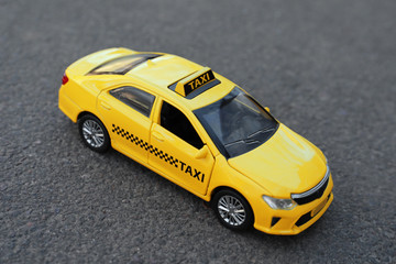 Obraz na płótnie Canvas Yellow taxi car model on city street