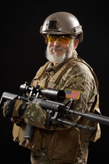 Military veteran with sniper rifle isolated on black.