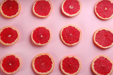 Obraz na płótnie Canvas Tasty ripe grapefruit slices on pink background, flat lay