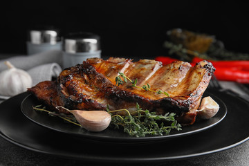 Tasty grilled ribs with thyme on grey table