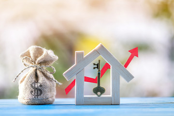 Master key put in the house and money bag and red arrow graph with growing value in the public...