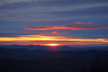 Colorful sunrise over layered mountains after ice storm in Blowing Rock, North Carolina.