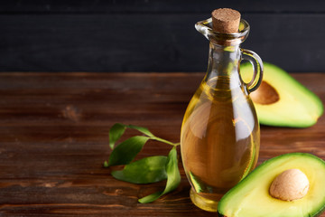 Obraz na płótnie Canvas Healthy Avocado oil in glass bottles. Dark background Copy space