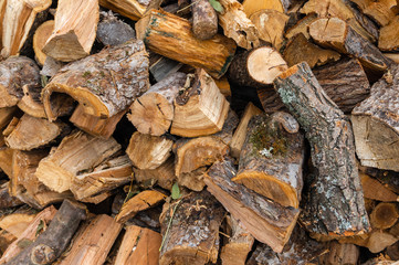 Cross section of the timber, firewood stack for the background. A lot of fire wood. Natural wooden decor background.