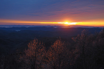 Colorful sunrise over layered mountains after ice storm in Blowing Rock, North Carolina.