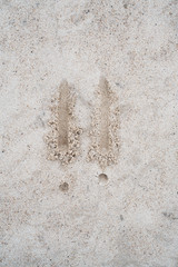 Exclamation mark sign drawn on beach sand.