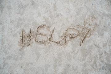 Help sign drawn on beach sand.