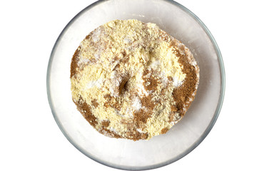 Corn and rice flour, brown coconut sugar in the transparent plate. White background. Copy space. Place for text and design. Gluten-free recipes. Healthy food.