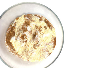 Corn and rice flour, brown coconut sugar in the transparent plate. White background. Copy space. Place for text and design. Gluten-free recipes. Healthy food.