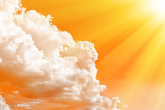Orange sky with white clouds and rays of hot sun.Conceptual photography on the theme of global warming