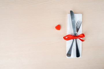 Fork and knife on a tissue near orange knick knack